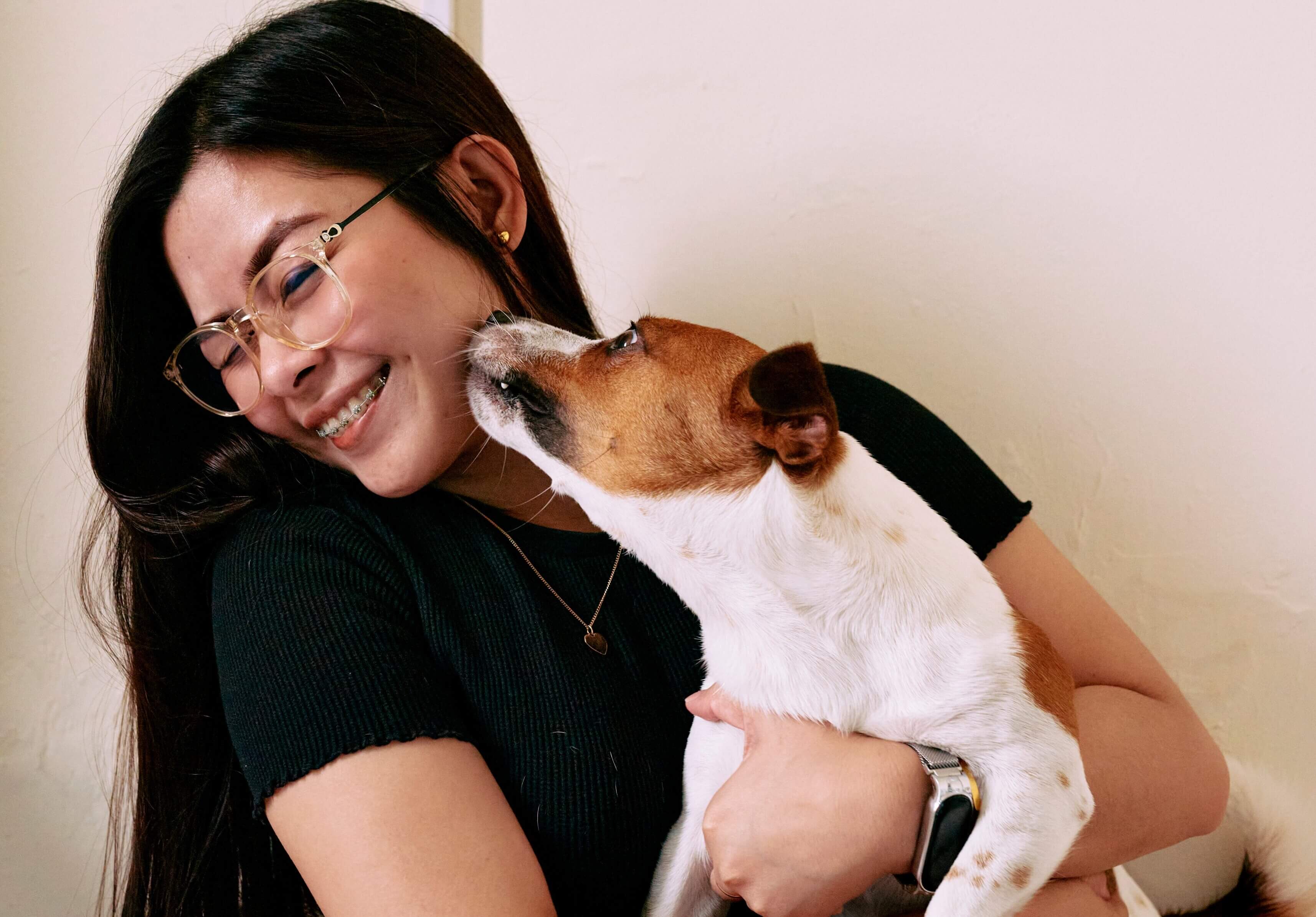 Joyful pet sitter shares a warm hug with her furry companion, showcasing a heartwarming bond between human and dog